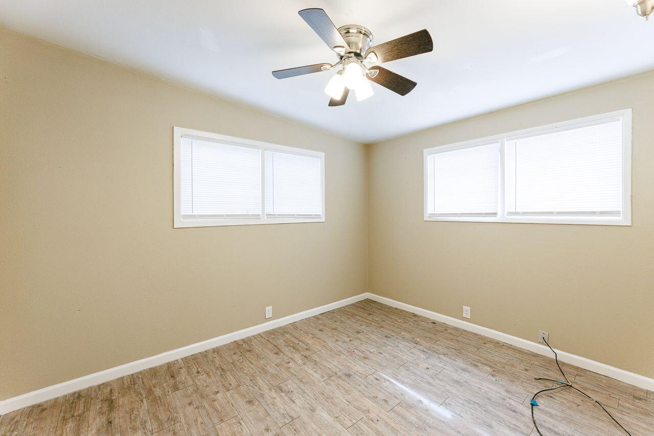 2107 48th Street Lubbock, TX 79412 - Photo 12 of 20 a view of a room with wooden floor and a ceiling fan