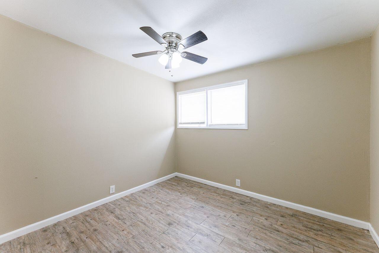 2107 48th Street Lubbock, TX 79412 - Photo 18 of 20 an empty room with wooden floor fan and windows