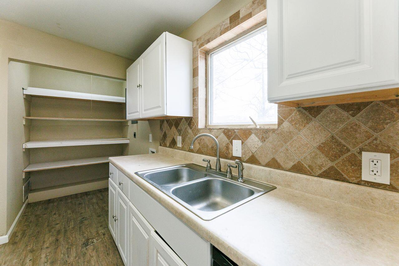 2107 48th Street Lubbock, TX 79412 - Photo 8 of 20 a kitchen with a sink cabinets and a window