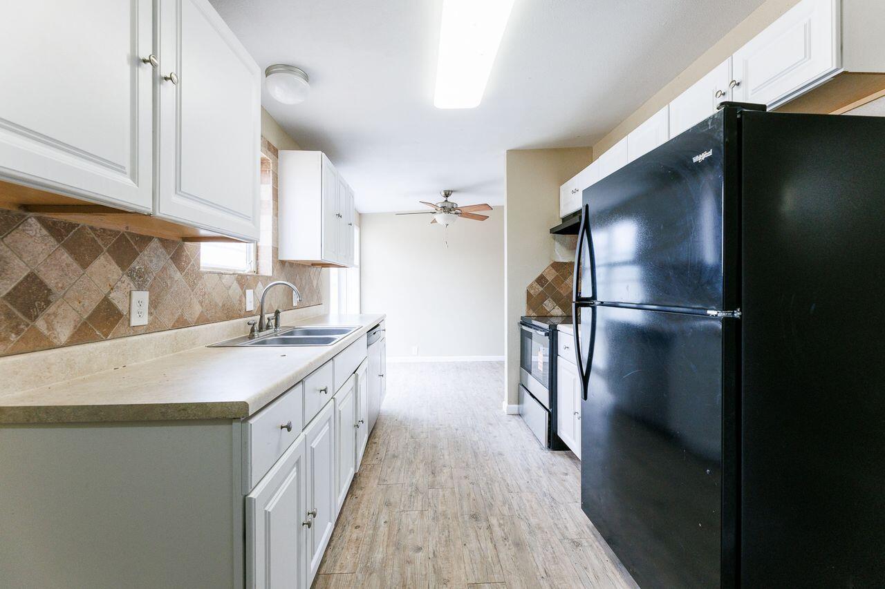 2107 48th Street Lubbock, TX 79412 - Photo 10 of 20 a kitchen with a sink and refrigerator