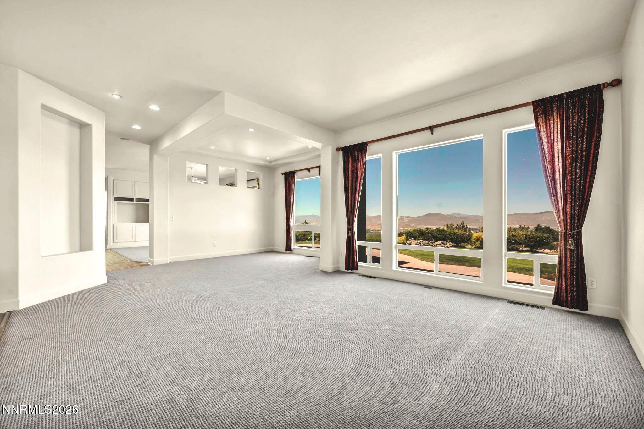 574 Echo Ridge Court Reno, NV 89511 - Photo 15 of 58 an empty room with a fireplace and large window