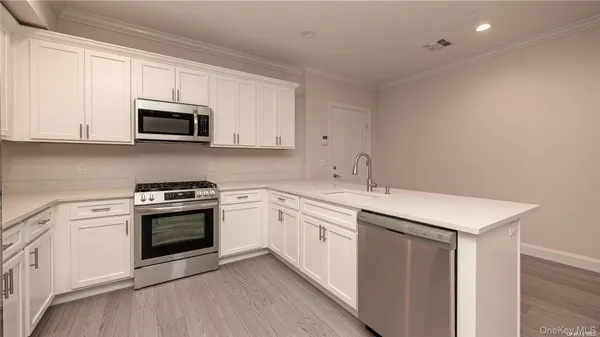 a kitchen with stainless steel appliances granite countertop a sink stove and microwave