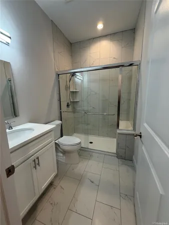 a bathroom with a granite countertop sink toilet and shower