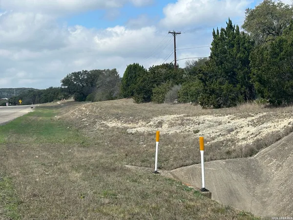a view of a dry yard with wooden fence