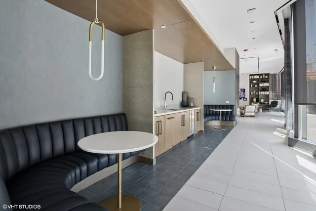 a kitchen with stainless steel appliances kitchen island granite countertop a table chairs in it and a sink