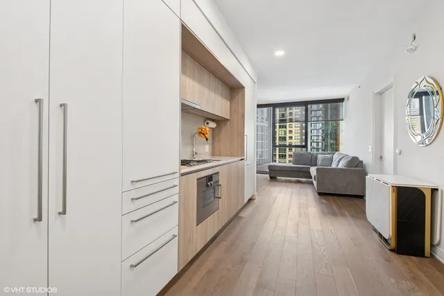 a kitchen with stainless steel appliances a sink and wooden floor