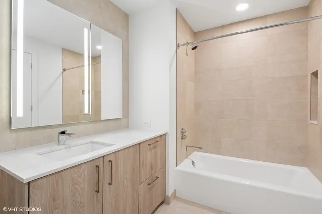 a bathroom with a sink double vanity mirror and a bathtub