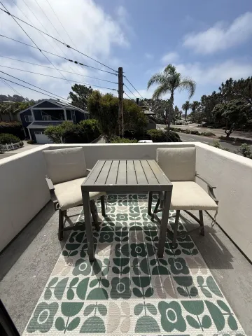 a view of a patio with table and chairs with wooden floor and fence