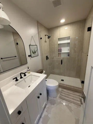 a bathroom with a sink a toilet and shower