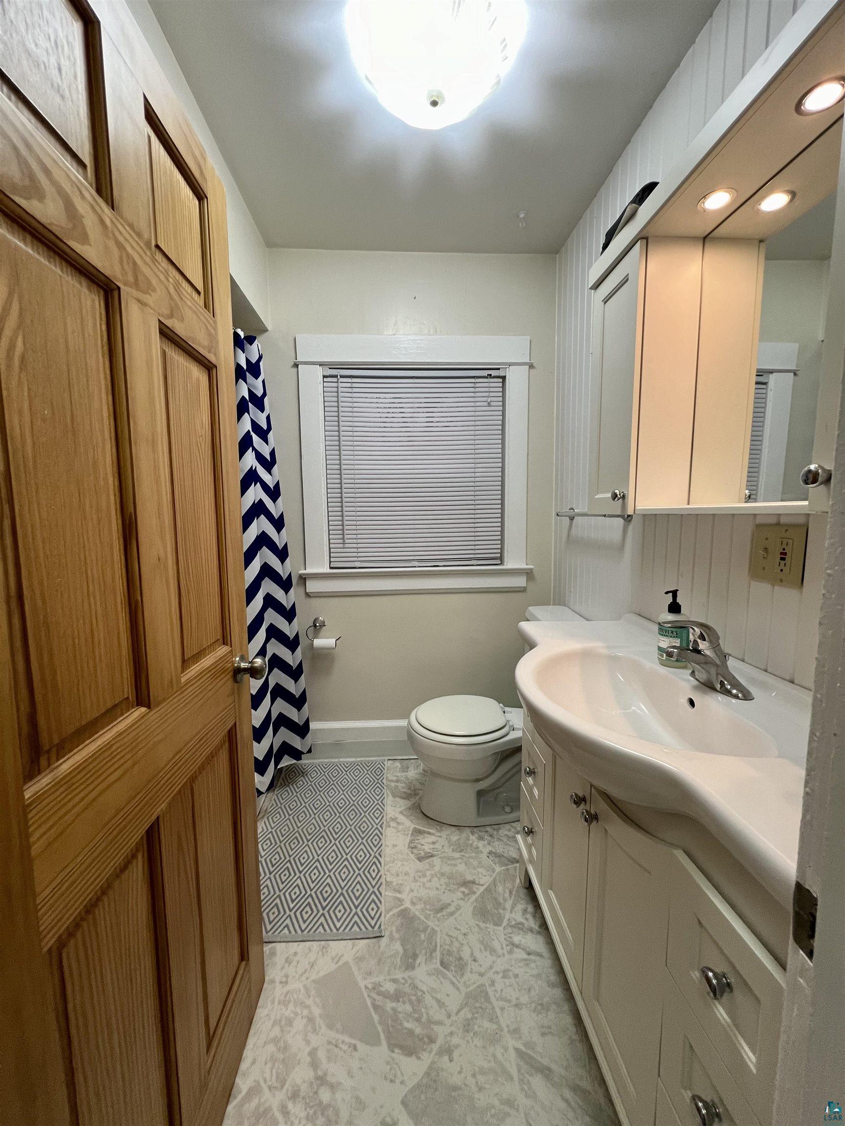 6512 Raleigh Street Duluth, MN 55807 - Photo 8 of 14 Full bathroom featuring vanity and curtained shower