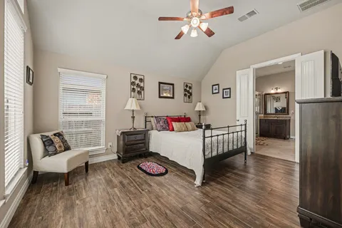a bedroom with a bed and wooden floor