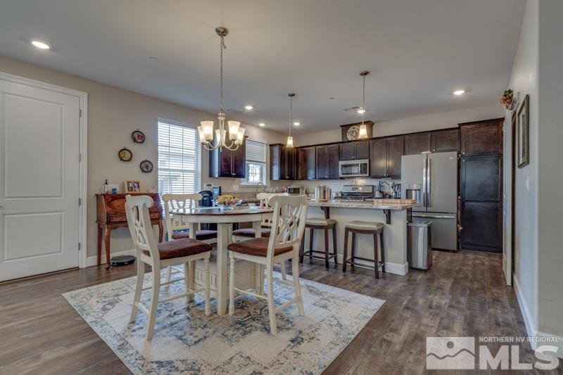 2024 Wind Ranch Road, Unit B Reno, NV 89521 - Photo 5 of 18 a kitchen with stainless steel appliances kitchen island granite countertop a table chairs and a refrigerator