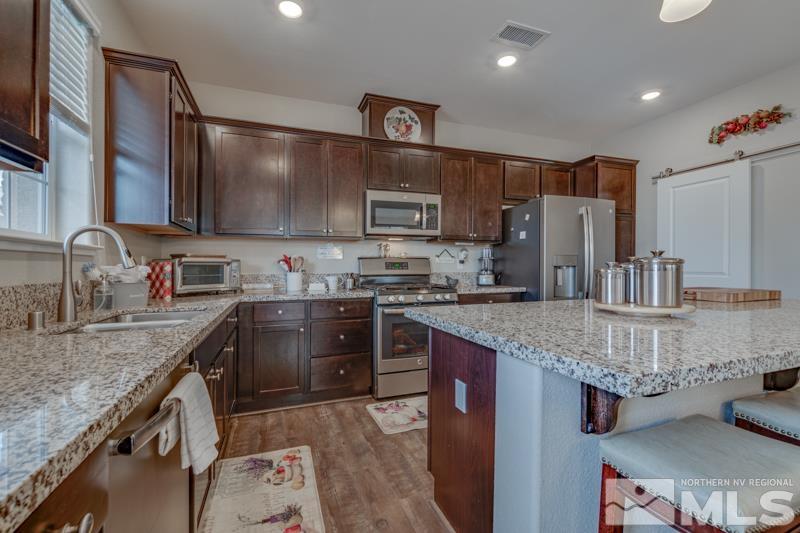 2024 Wind Ranch Road, Unit B Reno, NV 89521 - Photo 7 of 18 a kitchen with stainless steel appliances granite countertop a sink stove and refrigerator