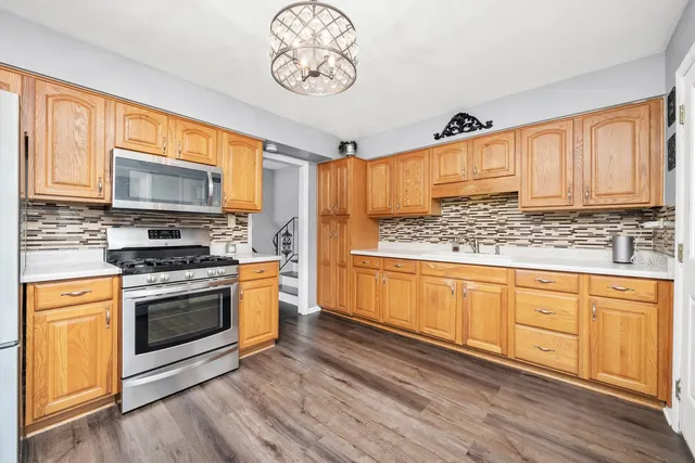 a kitchen with stainless steel appliances granite countertop a stove a sink and a microwave