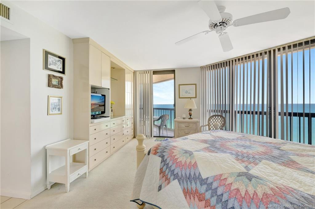 9500 South Ocean Drive, Unit HIGHER Jensen Beach, FL 34957 - Photo 11 of 53 a spacious bedroom with a bed and a chandelier