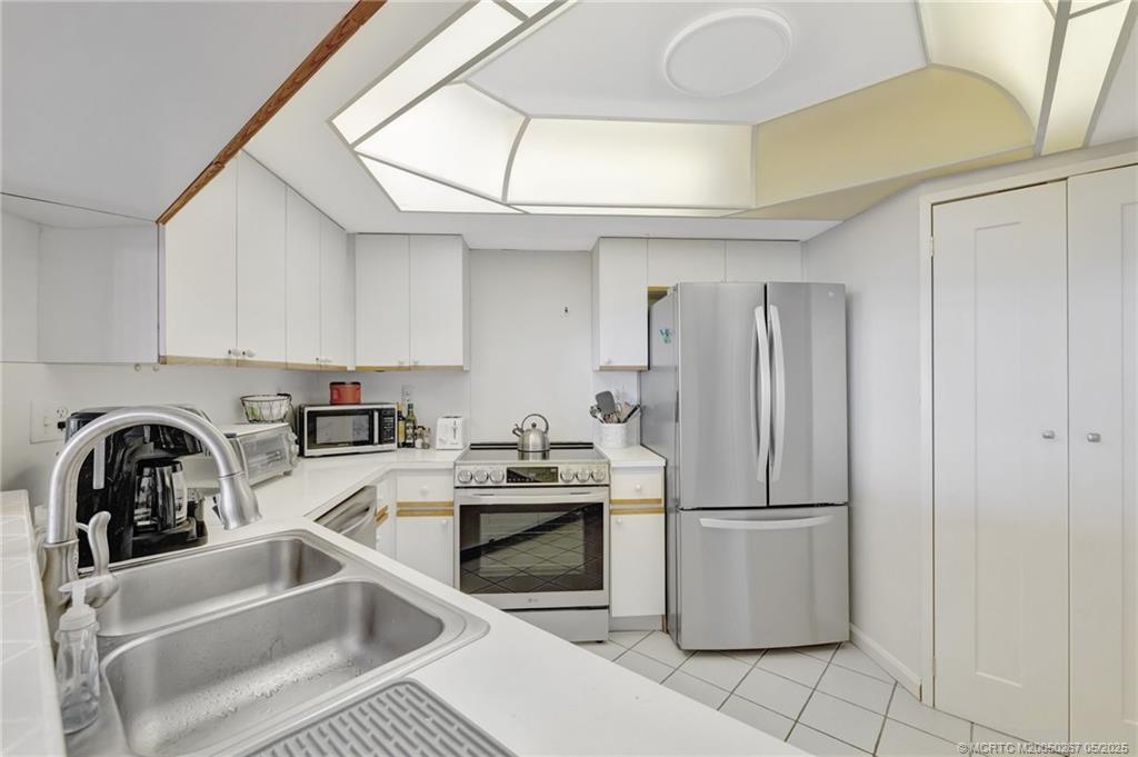 9500 South Ocean Drive, Unit HIGHER Jensen Beach, FL 34957 - Photo 15 of 53 a kitchen with a sink a refrigerator and cabinets