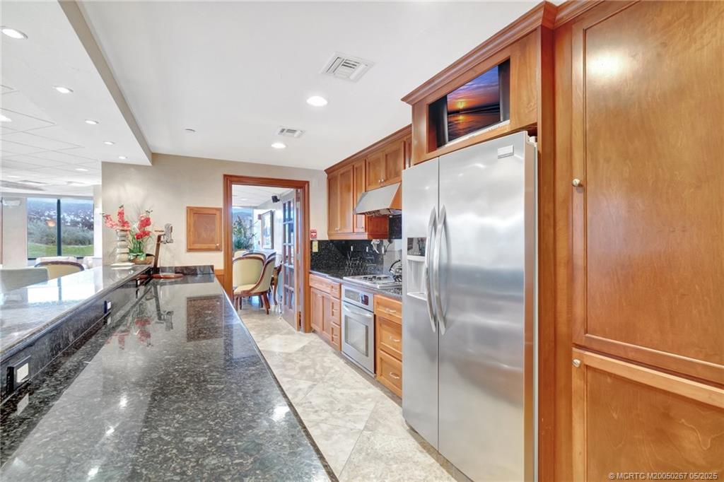 9500 South Ocean Drive, Unit HIGHER Jensen Beach, FL 34957 - Photo 50 of 53 a kitchen with stainless steel appliances granite countertop a refrigerator a stove and a sink with cabinets