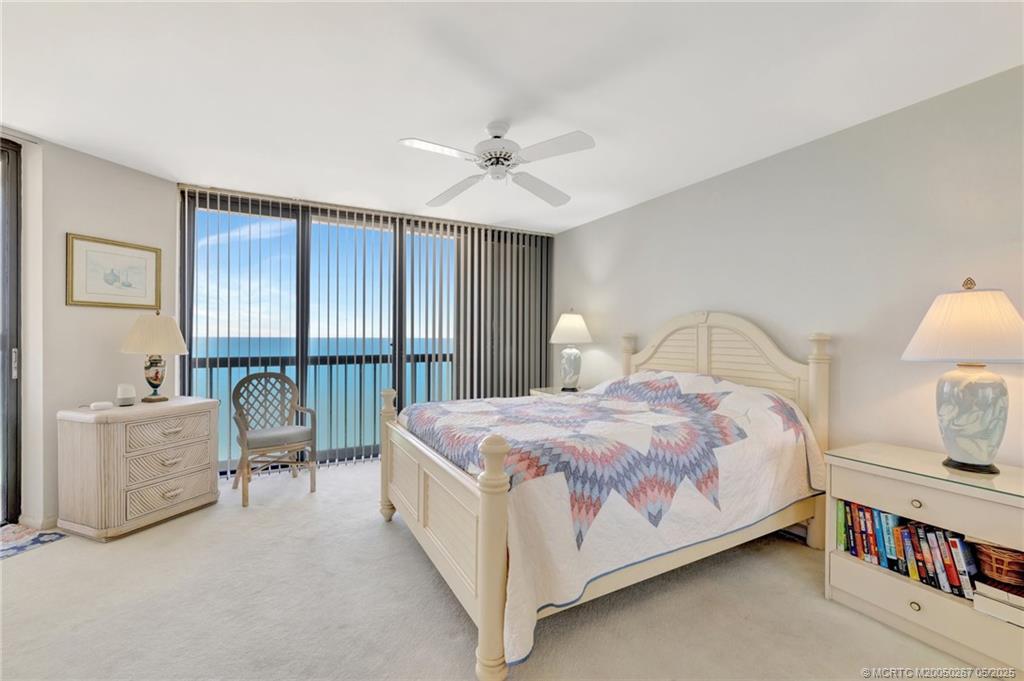 9500 South Ocean Drive, Unit HIGHER Jensen Beach, FL 34957 - Photo 8 of 53 a bed room with a bed and a chandelier