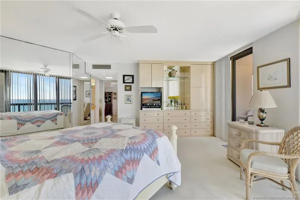 a bedroom with a bed a large window and furniture