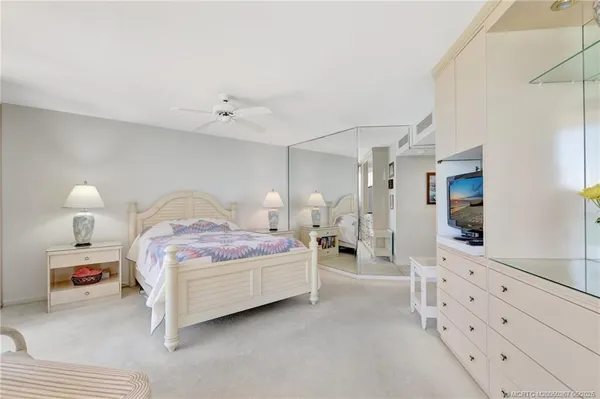 a bedroom with a bed and a lamp on dresser