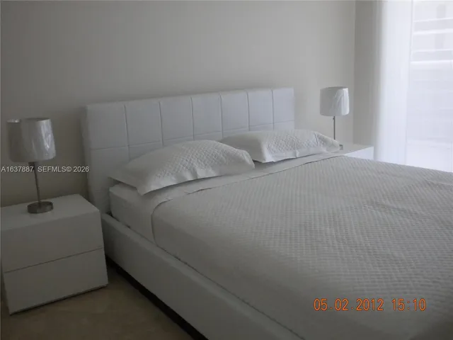 a bedroom with a bed and a lamp