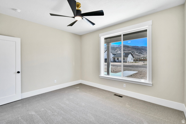 840 South Jones Road Monroe, UT 84754 - Photo 26 of 52 Neutral wall paint, carpeted flooring, a ceiling fan with integrated lighting, a sliding window, and a flat-panel interior door with matte black hardware