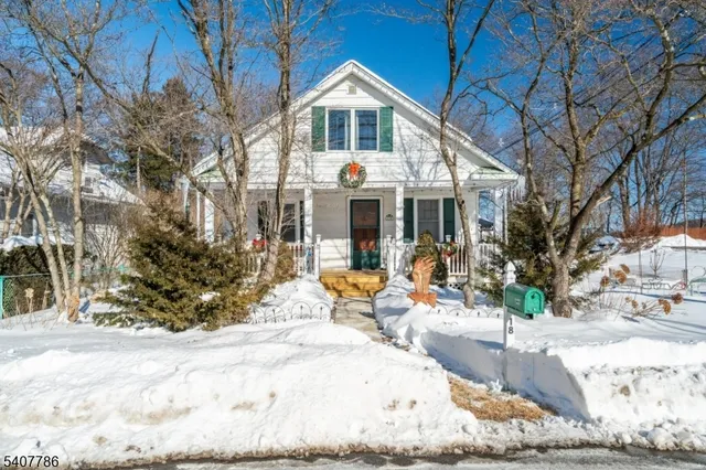 a front view of a house with garden and trees