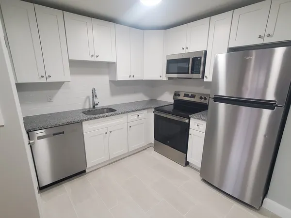 a kitchen with stainless steel appliances a refrigerator sink and microwave