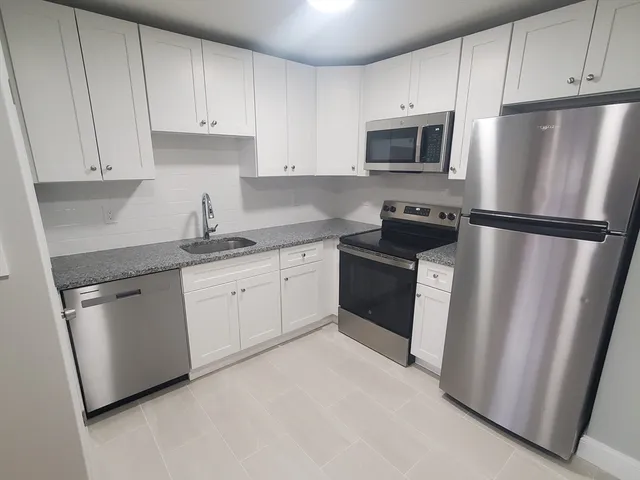 a kitchen with stainless steel appliances a refrigerator sink and microwave