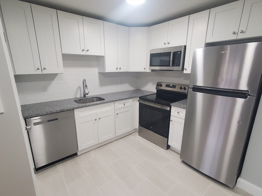 4 Oakcrest Road, Unit 31 Boston, MA 02136 - Photo 1 of 12 a kitchen with stainless steel appliances a refrigerator sink and microwave