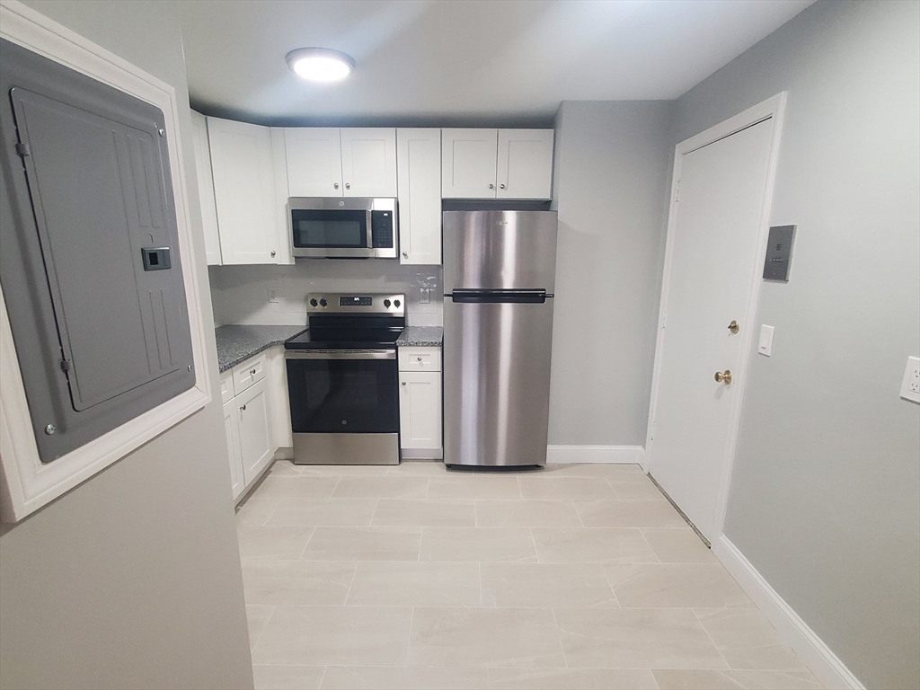 4 Oakcrest Road, Unit 31 Boston, MA 02136 - Photo 2 of 12 a kitchen with stainless steel appliances a refrigerator and a stove top oven