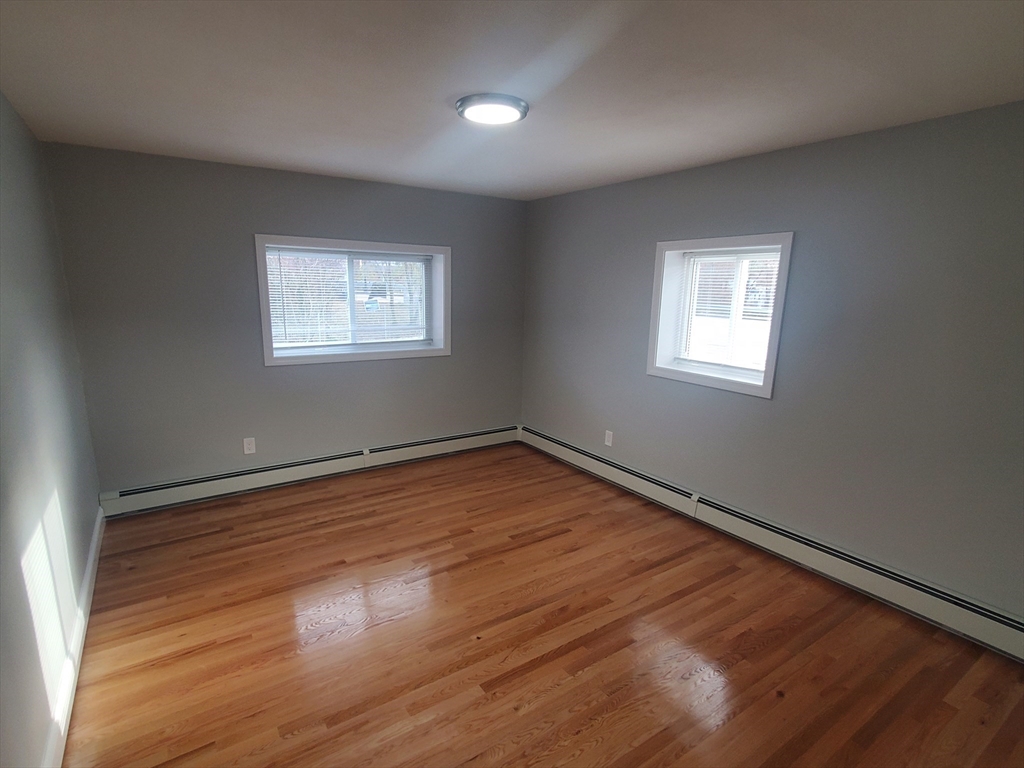 4 Oakcrest Road, Unit 31 Boston, MA 02136 - Photo 4 of 12 an empty room with wooden floor and windows