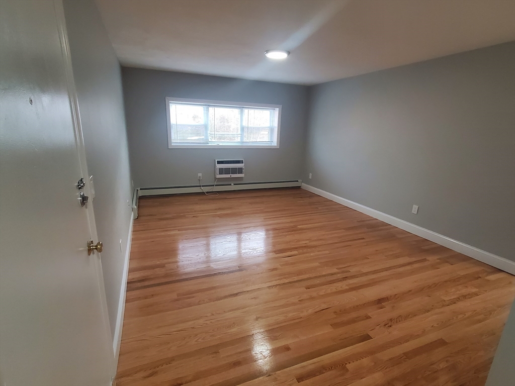 4 Oakcrest Road, Unit 31 Boston, MA 02136 - Photo 5 of 12 an empty room with wooden floor and windows