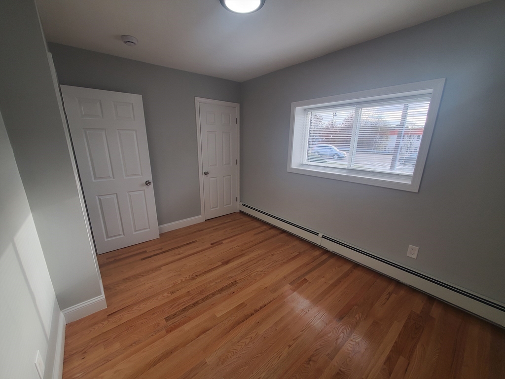 4 Oakcrest Road, Unit 31 Boston, MA 02136 - Photo 8 of 12 a view of an empty room with wooden floor and a window