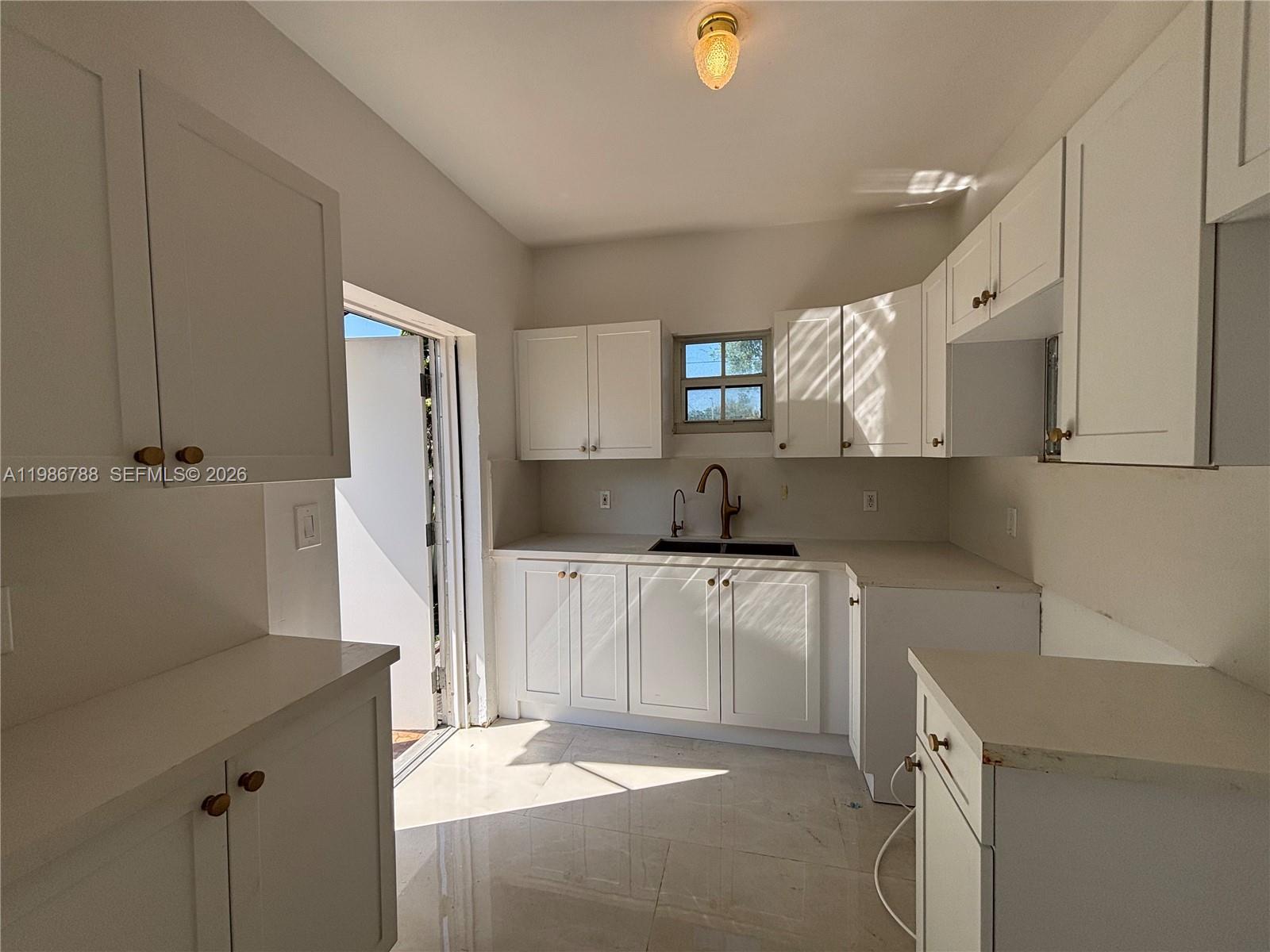 521 Northwest 48th Street Miami, FL 33127 - Photo 5 of 30 a kitchen with a sink cabinets and appliances