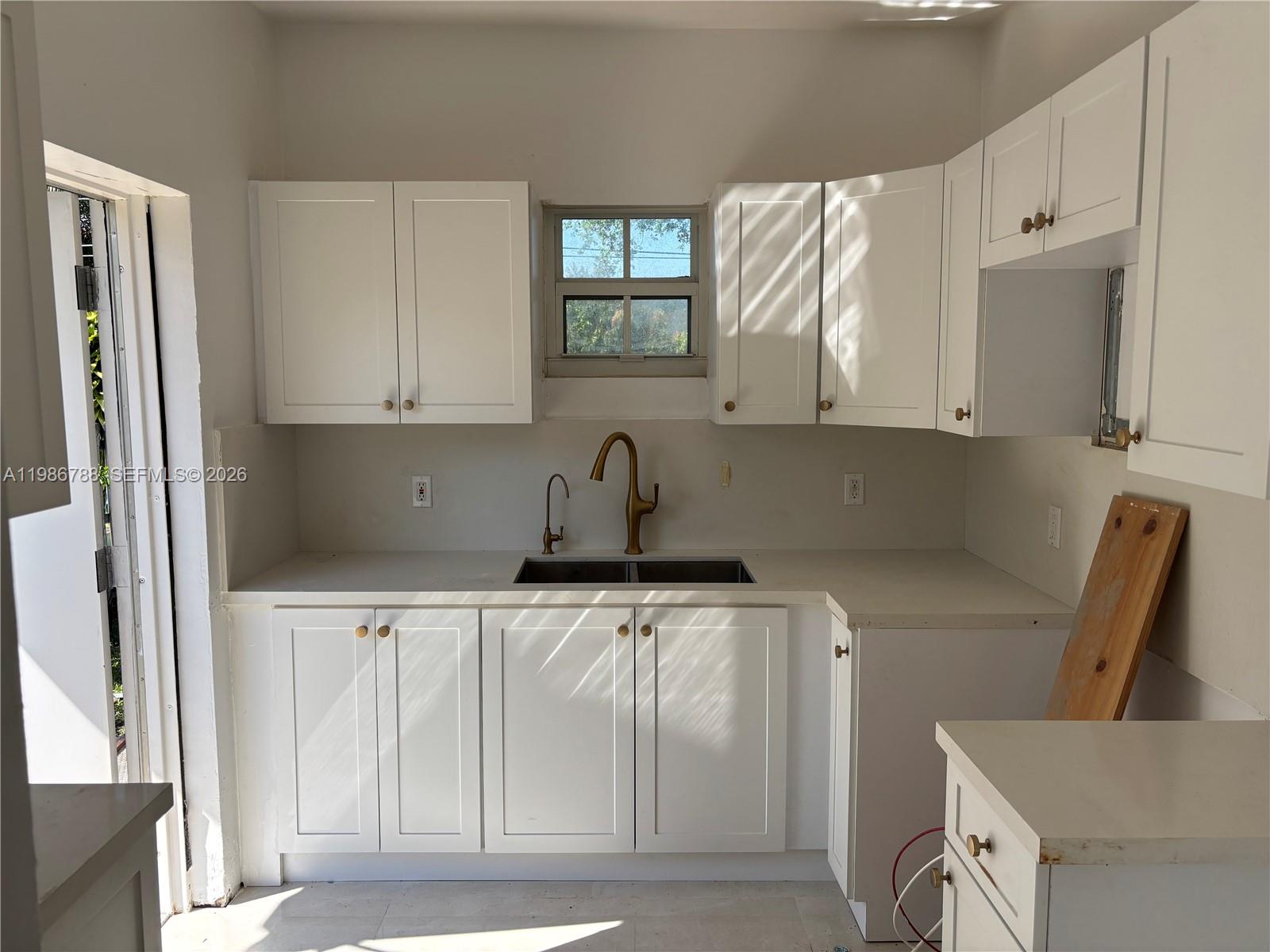 521 Northwest 48th Street Miami, FL 33127 - Photo 8 of 30 a kitchen with a sink a refrigerator and cabinets