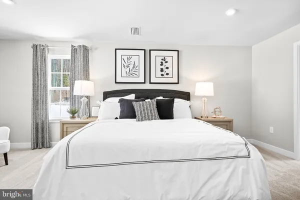 a view of a hallway with wooden floor and a bathroom