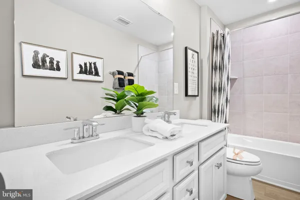 a kitchen with stainless steel appliances white cabinets and a refrigerator