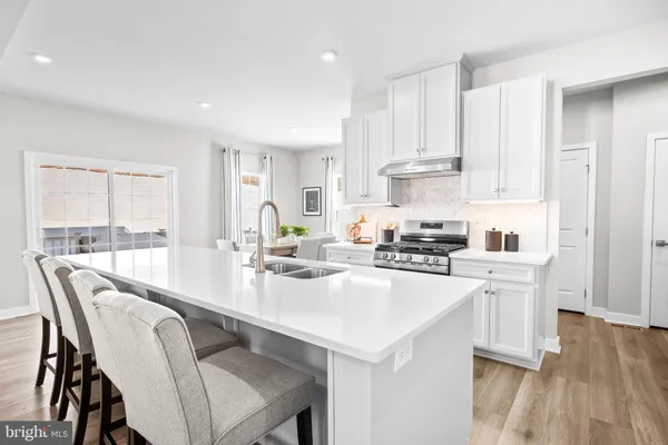 a kitchen with a dining table chairs and white cabinets
