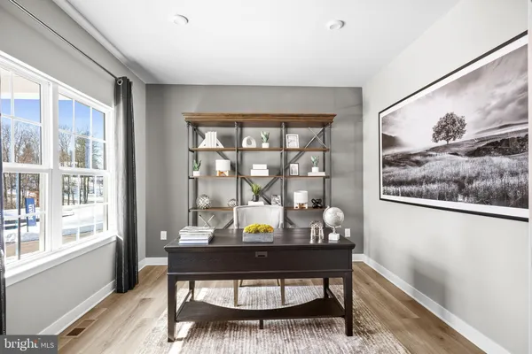 a kitchen with stainless steel appliances granite countertop a stove white cabinets a dining table and chairs