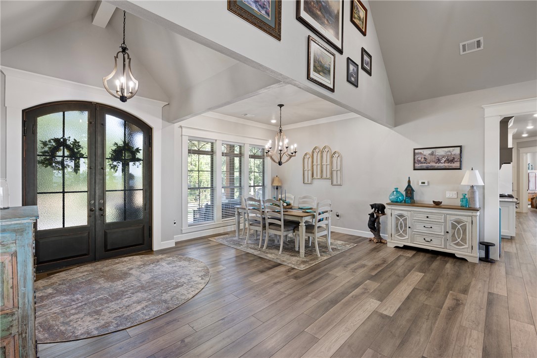 3419 Bailey Loop Road London, AR 72847 - Photo 8 of 60 Arched double entry doors with opaque glass, wood-finish flooring, vaulted ceiling, recessed lighting, and a chandelier