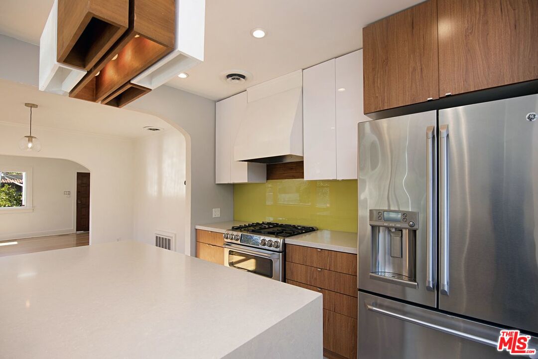 3749 Griffith View Drive Los Angeles, CA 90039 - Photo 12 of 34 a kitchen with stainless steel appliances a refrigerator a stove and white cabinets