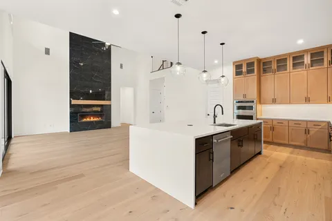 a large white kitchen with stainless steel appliances granite countertop a stove and a refrigerator