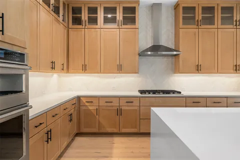 a kitchen with stainless steel appliances granite countertop a stove and a white cabinets