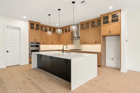 a kitchen with kitchen island a sink stainless steel appliances and cabinets
