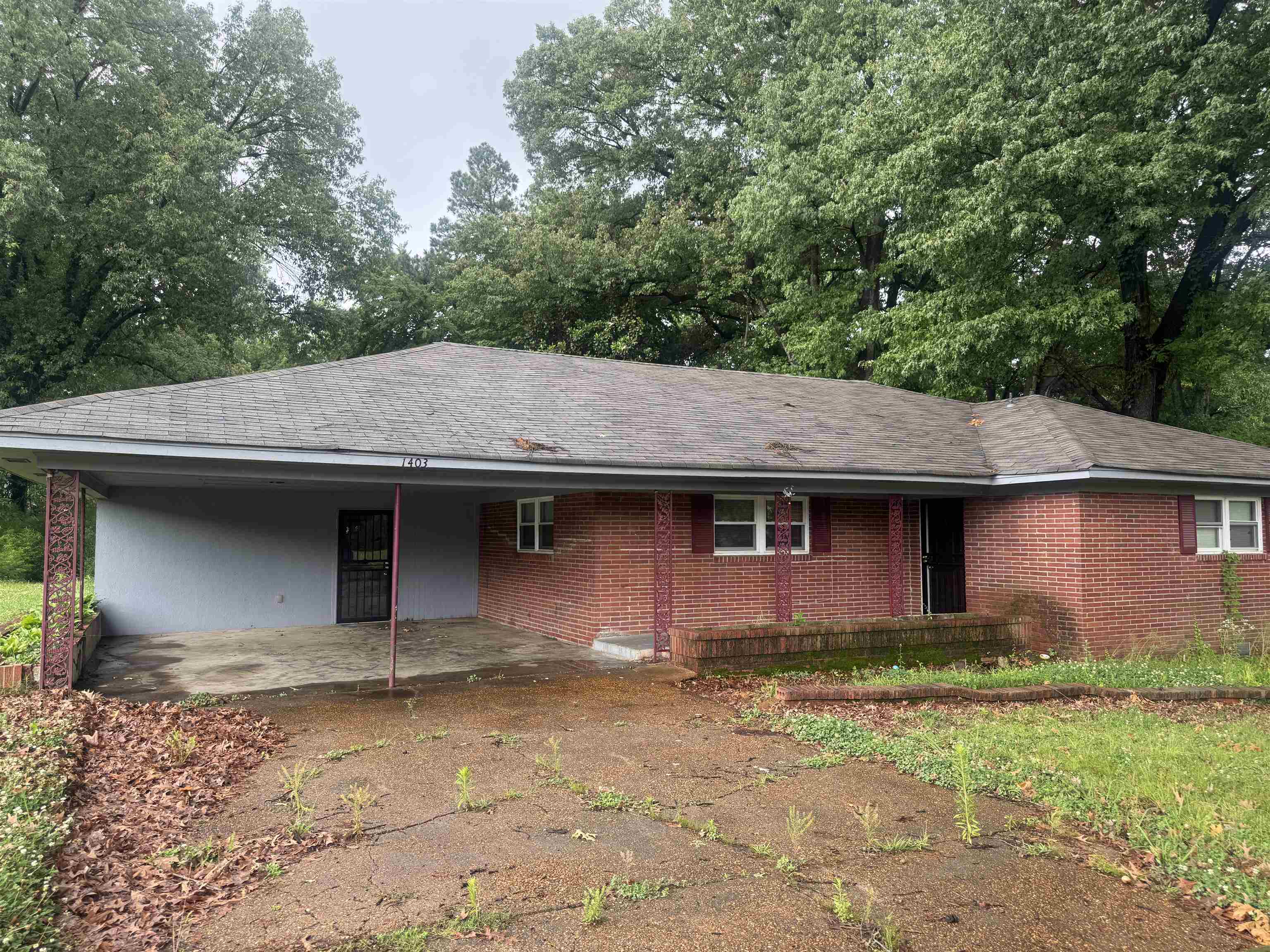 1403 Old Hickory Road Memphis, TN 38116 - Photo 3 of 31 Brick exterior with a covered carport featuring decorative metal support columns and a dark security door