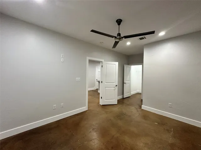 an empty room with staircase and windows