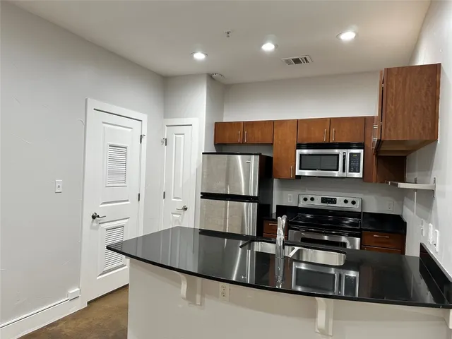 a kitchen with stainless steel appliances granite countertop a stove and a refrigerator