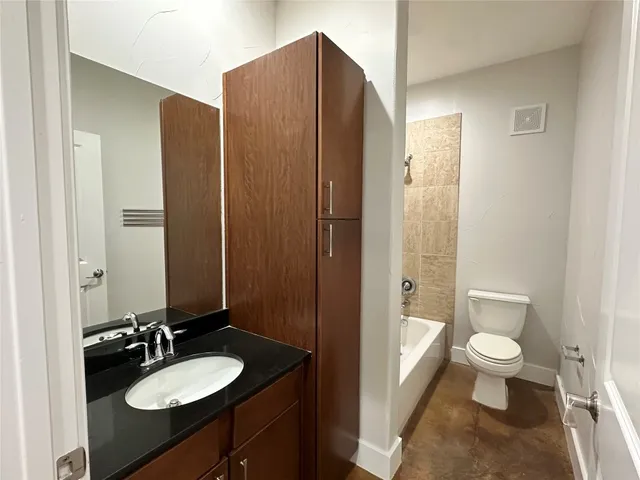 a bathroom with a granite countertop sink toilet and shower