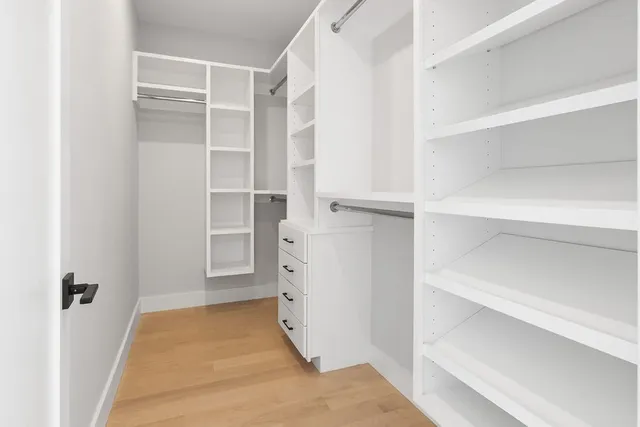 a view of walk in closet with empty racks